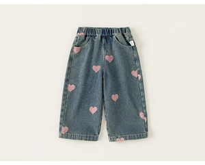 Detail of girls' blue denim jeans featuring pink sequin heart embroidery and elastic waist