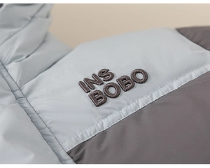 Detail of contrast color winter down jacket with INS BOBO embroidery on the chest