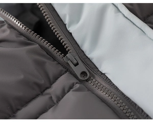 Close-up of contrast zipper detail on quilted down jacket with blue lining