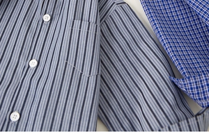Close-up of boys' blue and white striped cotton shirt with button detail and pocket