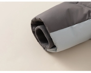 Detailed close-up of color-blocked puffer jacket sleeves with windproof ribbed knit cuffs