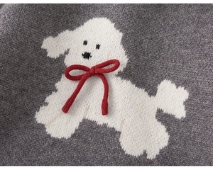 Dettaglio maglione grigio con jacquard a barboncino bianco e fiocco rosso 3D applicato