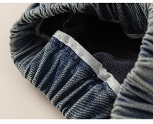 Detailed close-up of dark blue denim fabric with thick grey fleece lining for warmth
