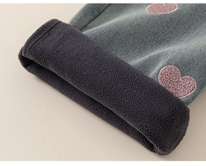 Detailed close-up of girls denim jeans with warm grey fleece lining and pink heart embroidery
