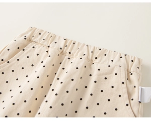 Detail einer beigen gepunkteten Kinderhose mit elastischem Bund und Seitentaschen