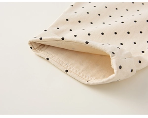 Makroaufnahme von Polka-Dot-Muster auf beige Baumwollstoff mit detaillierter Naht