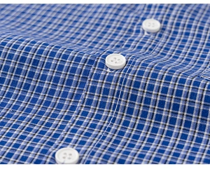 Close-up of blue and white checkered shirt fabric with detailed stitching and white buttons
