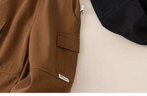 Detailaufnahme der braunen und schwarzen Baumwoll-Cargohose mit modischen Taschen