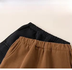 Makroaufnahme des elastischen Kinderbundes an schwarzen und karamellfarbenen Cargohosen