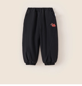 Detail of kids black winter sweatpants featuring a red Fu character and cloud pattern