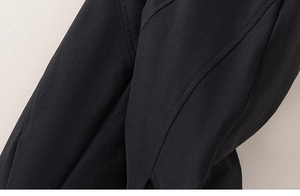 Close-up of black children's padded pants showing textured fabric and fine stitching detail