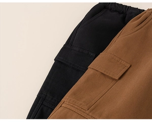 Details von elastischen Bünden und Cargotaschen an schwarzen und braunen Kinderhosen
