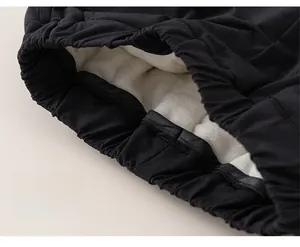 Close-up of kids' winter pants showing thick white fleece lining and elastic cuff detail