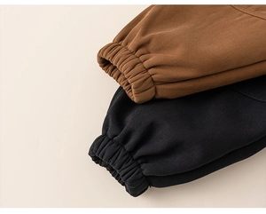 Detail der elastischen Beinbündchen an Kinder-Cargohosen in Braun und Schwarz aus Baumwolle