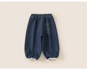 Détail du jean doublé pour filles montrant l'ourlet en dentelle et la taille élastique