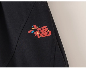 Close-up detail of black fabric showing durable texture and colorful Fu character print