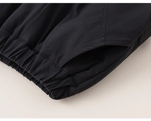 Detail view showing elastic waistband and side pockets on black kids winter trousers