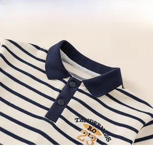 Detailed close-up of a striped polo shirt collar with embroidered lettering and navy trim