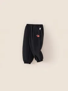 Kids black festive fleece sweatpants with red Fu character and elastic cuffs