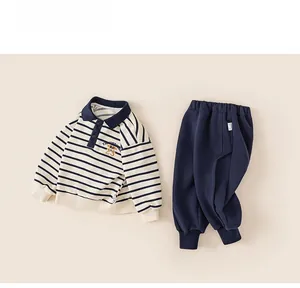 Close-up of boys' striped polo sweatshirt and navy jogger pants set with ribbed cuffs