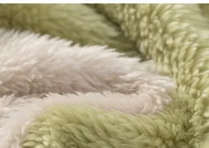 Close-up of thick plush green and cream fleece fabric showing soft textured fibers