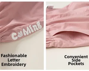 Détails d'un jogging rose en coton avec broderie de lettres et poches latérales