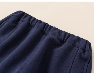 Detail of the elastic waistband on dark blue ribbed knit trousers for boys