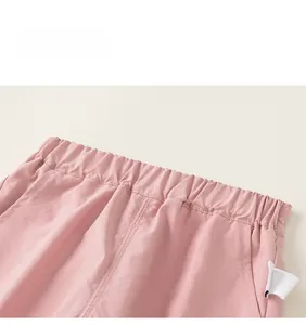 Vue détaillée de la taille élastique d'un pantalon rose avec étiquette blanche