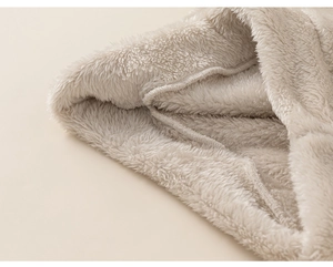 Detailed close-up of fluffy cream coral fleece fabric with premium stitching for warmth