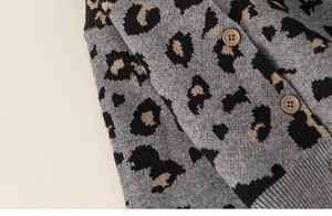 Detail of leopard print knit cardigan showing fabric texture and brown round buttons
