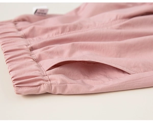 Détail d'un pantalon décontracté rose avec taille élastique et texture de tissu fine