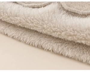 Close-up of thick cream fleece pajama fabric with soft texture and neat stitching