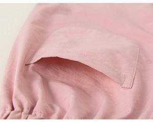 Détail du pantalon de jogging rose clair avec poche latérale et ourlet élastique