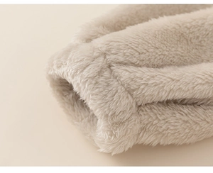 Close-up of soft beige fleece fabric showing warm plush texture and cuff stitching detail