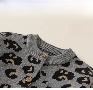 Close-up of classic round neckline and dark buttons on leopard print knitted cardigan
