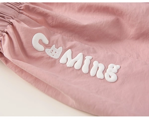 Détail du jogging rose avec broderie chat COMING blanche et taille élastique souple