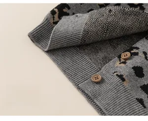 Detail of leopard jacquard cardigan hem with ribbed cuffs and brown buttons