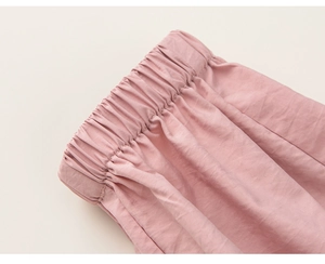 Détail de la taille élastique d'un pantalon rose pour fille aux coutures soignées