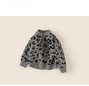 Close-up of leopard print knitted cardigan for kids with natural wooden button details