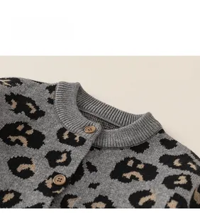 Detail of leopard print knitted cardigan with ribbed neckline and brown buttons