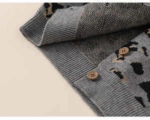 Close-up of leopard print knit cardigan with detailed brown buttons and ribbed cuffs