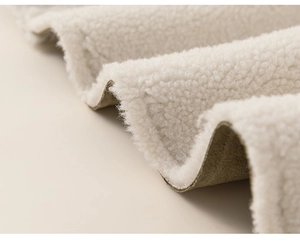 Macro detail of thick white sherpa fleece and khaki suede lining for warm winter jackets