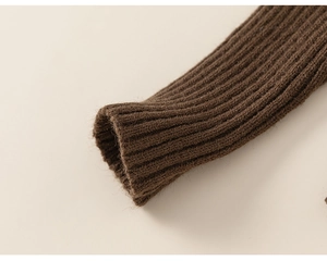 Detailed close-up of dark brown ribbed knit cuffs on a warm children's turtleneck sweater