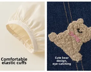 Détail du jean bébé montrant un écusson ours en peluche et des poignets élastiques brodés