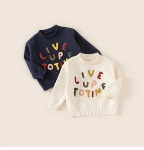 Detail of colorful textured 3D letters on soft cotton knit sweaters for kids