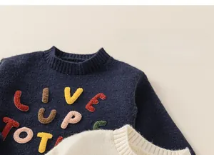 Detail of round neckline and colorful chenille embroidery on kids knitted sweaters