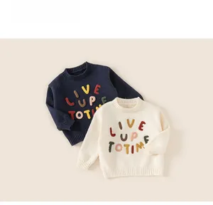 Close-up of kids' round neck sweaters with colorful LIVE UP TO TIME letter embroidery