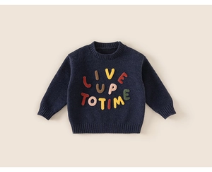 Detail showing colorful embroidered 3D letters on navy blue knit sweater for children