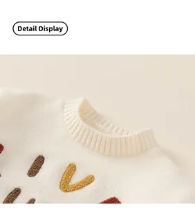 Detail of ribbed crew neck and textured embroidery on cream knit sweater for kids