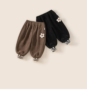 Détail du pantalon en velours côtelé pour bébé avec broderie florale et ourlet à cœurs